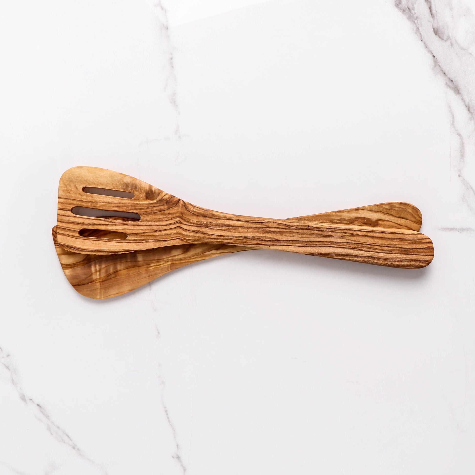Versatile Wooden Spatula from Olive Wood, expertly hand-carved for cooking lovers. Its slotted design makes it perfect for a variety of tasks, from flipping to serving. A beautiful, practical kitchen tool that adds a rustic charm to any utensil collection.
