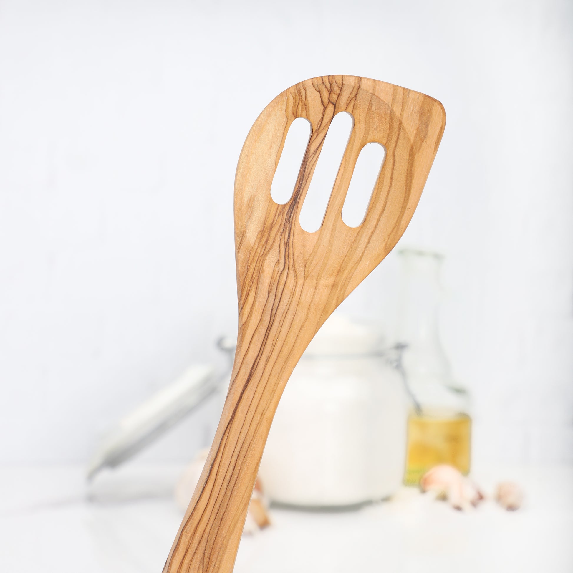 Versatile Wooden Slotted Spatula made from olive wood, perfect for turning and draining. Each spatula is handcrafted, showcasing the wood's natural beauty and ensuring no two pieces are alike, enhancing any kitchen utensil collection.