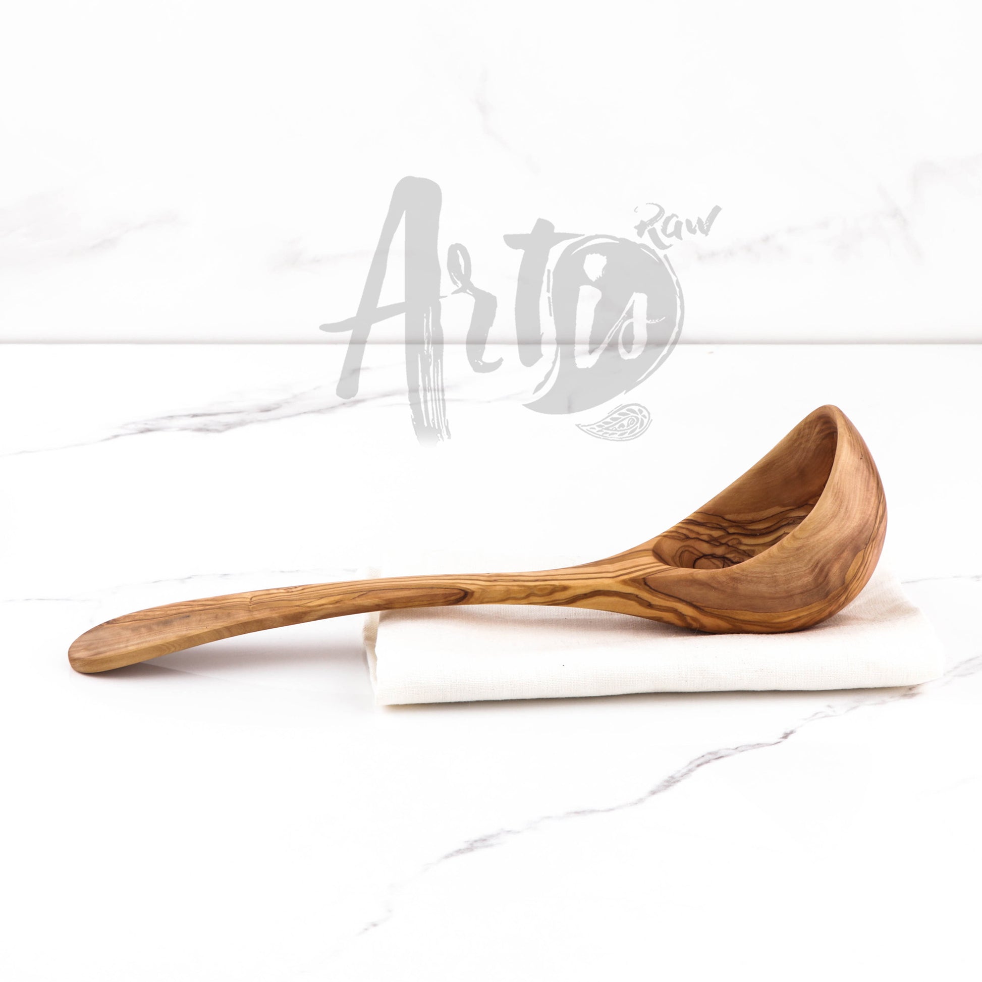 Versatile olive wood ladle spoon, perfect for every kitchen with its unique hand-carved design. Serving as both a practical tool for soups and stews and a beautiful piece of art, it embodies the durability and aesthetic appeal of olive wood. Care instructions ensure this wooden flatware remains a centerpiece of your eco-friendly kitchen tools.
